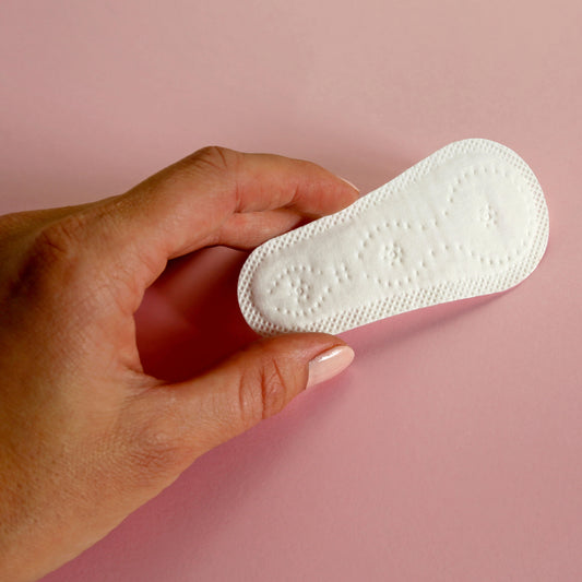 Frau hält Mini-Slipeinlage in der Hand